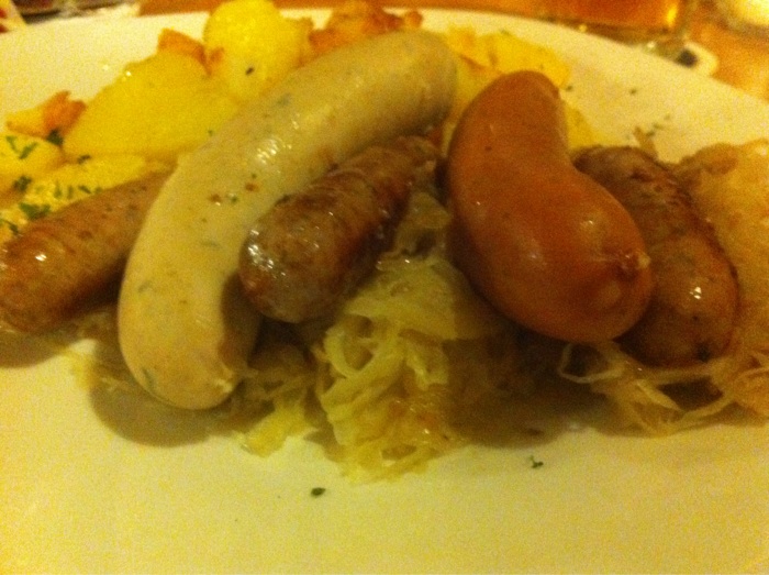 Würstlteller. Weißwurscht, Nürnberger, Regensburger, Bratkartoffeln, Sauerkraut