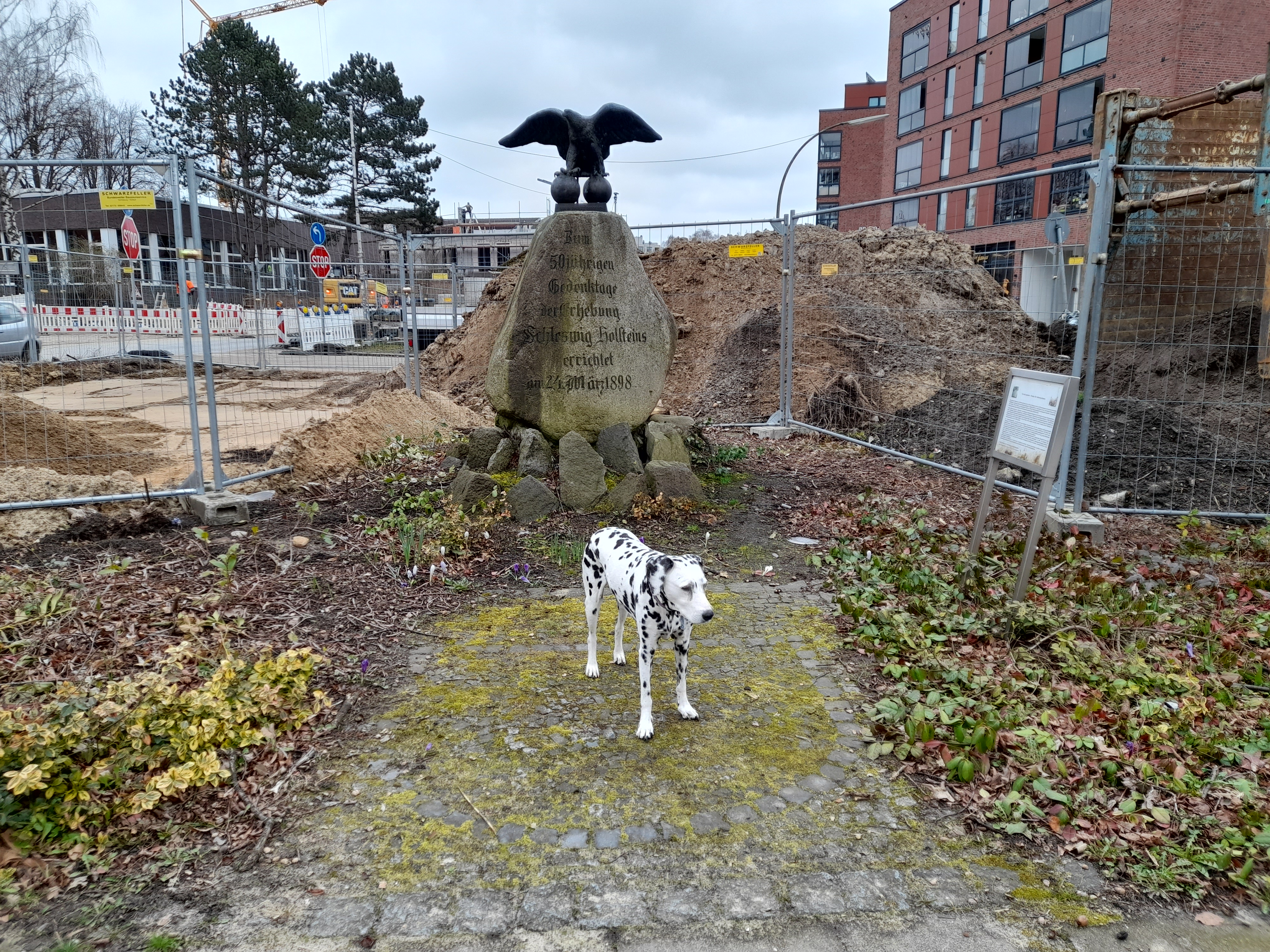 Gedenkstein mit Adler auf Kanonenkugel am Bramfelder Dorfplatz