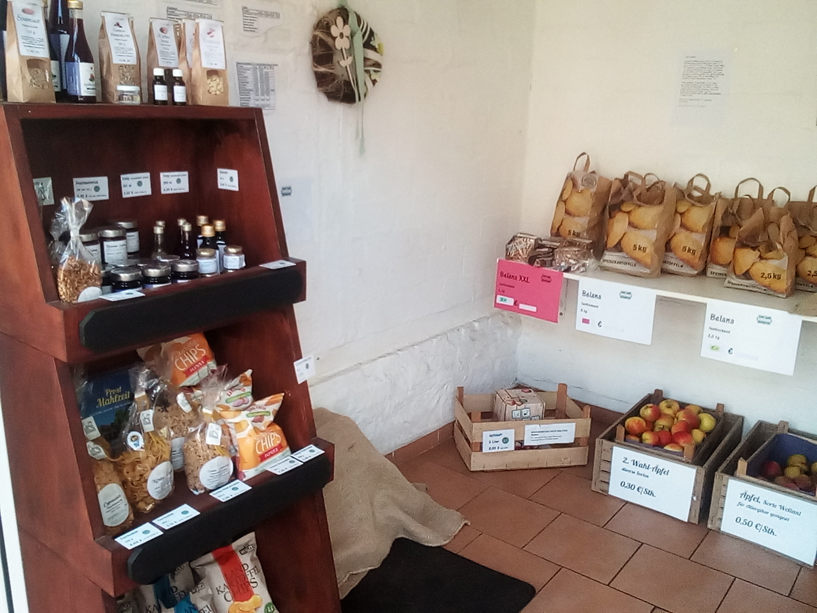 SB-Hofladen mit Kartoffeln, Äpfeln, Chips, Nudeln, Saft, Aroniaprodukten, Brötchen zum Aufbacken und Brot