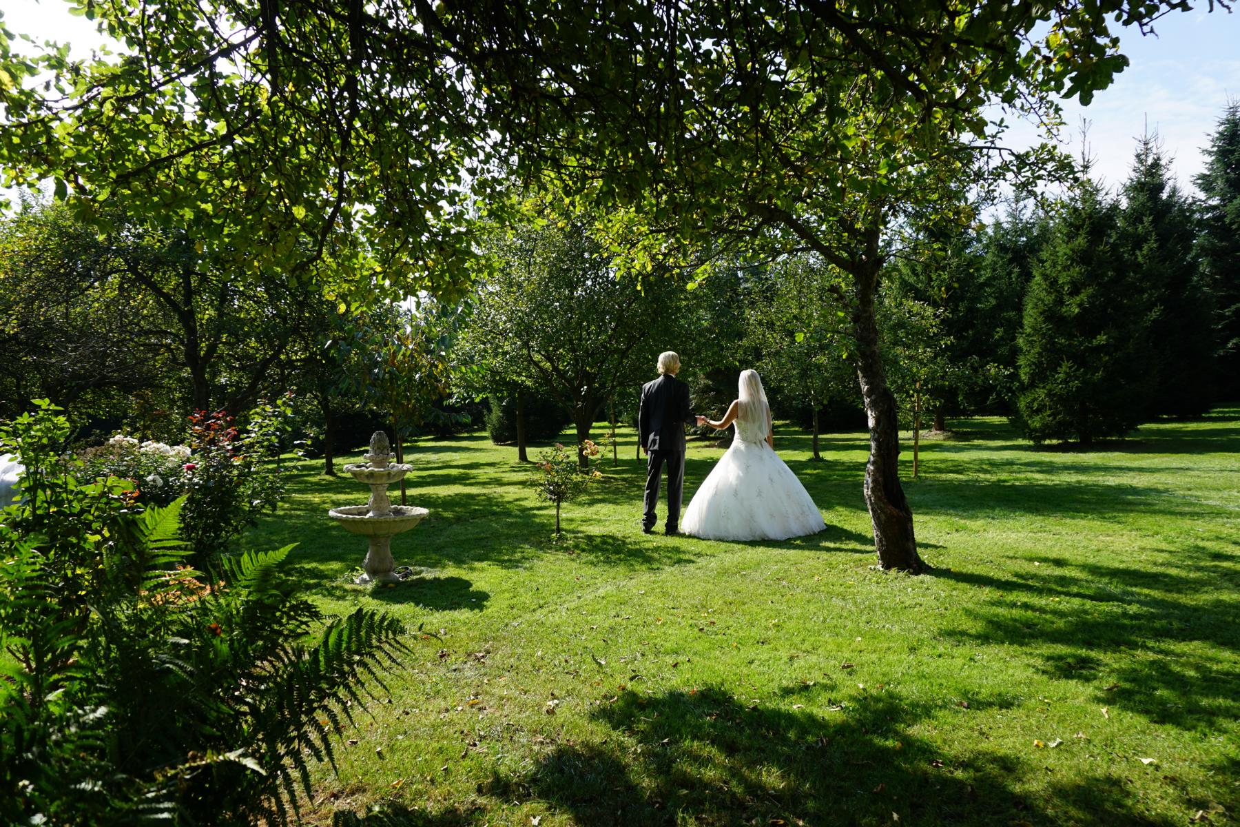 Brautpaar im Obstgarten und Park der Hochzeitskapelle