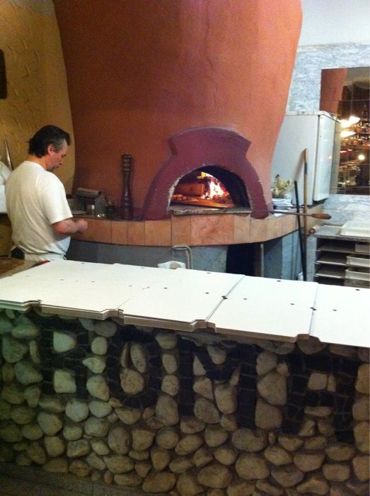 Hier bäckt der Chef die Pizza noch ganz klassisch im Holzofen.