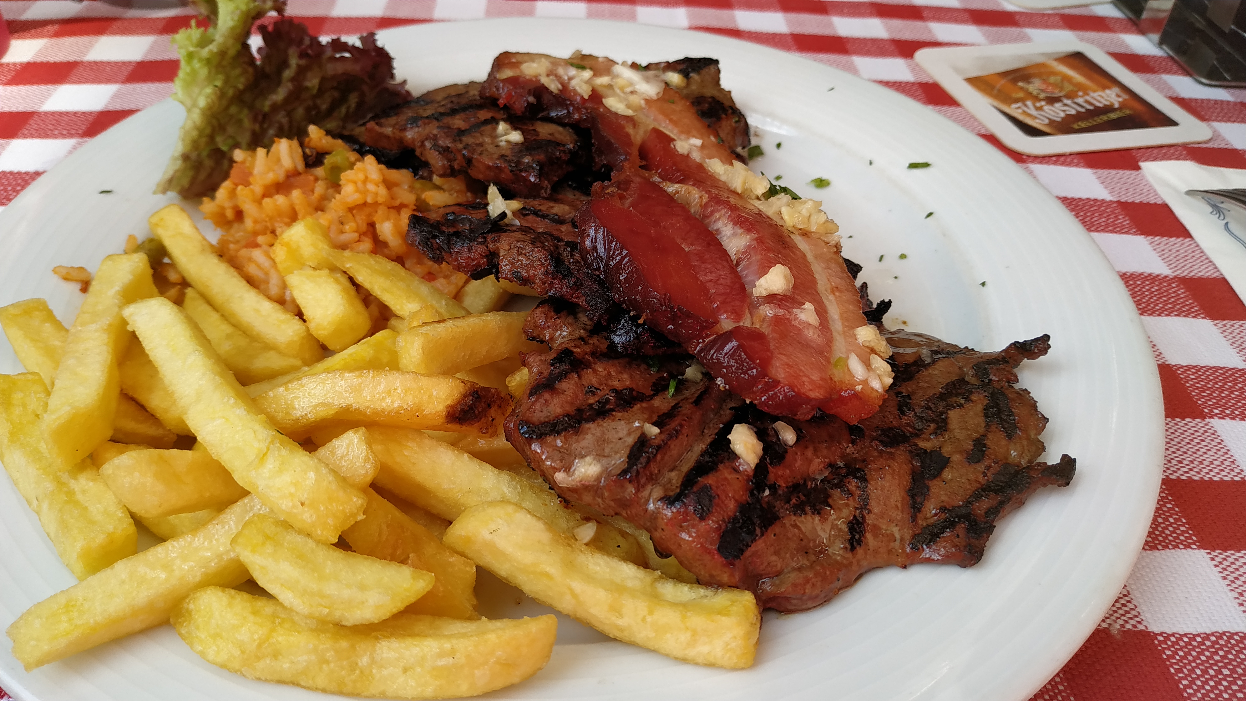 104. Balkanleber ((mit Knoblauch) gegrillte Rinderleber und eine Scheibe Speck, mit Pommes frites, Djuvecreis und Salat)