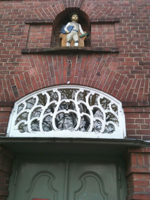 Knabenfigur, farbig glasierte Terrakotta von Theodor von Gosen an der ehem. Knabenschule in der Gartenstadt Staaken, Architekt: Paul Schmitthenner, 