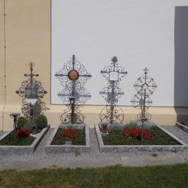 Gräber einstiger Pfarrer an der Kirchenmauer