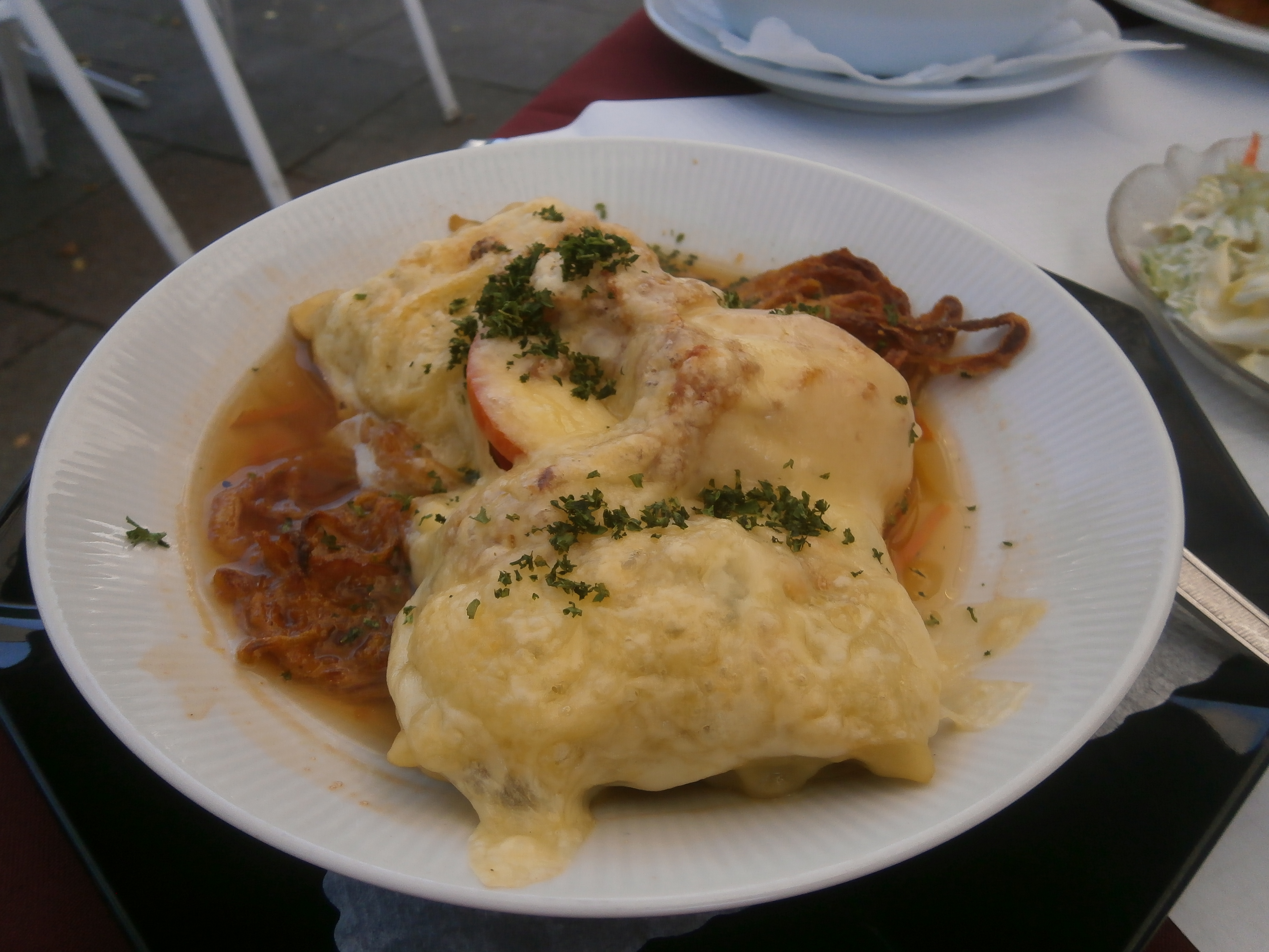 Maultaschen und Röstzwiebelchen in der Brühe mit Tomaten und Käse überbacken für 11,80 Euro. Salat gabs auch noch dazu