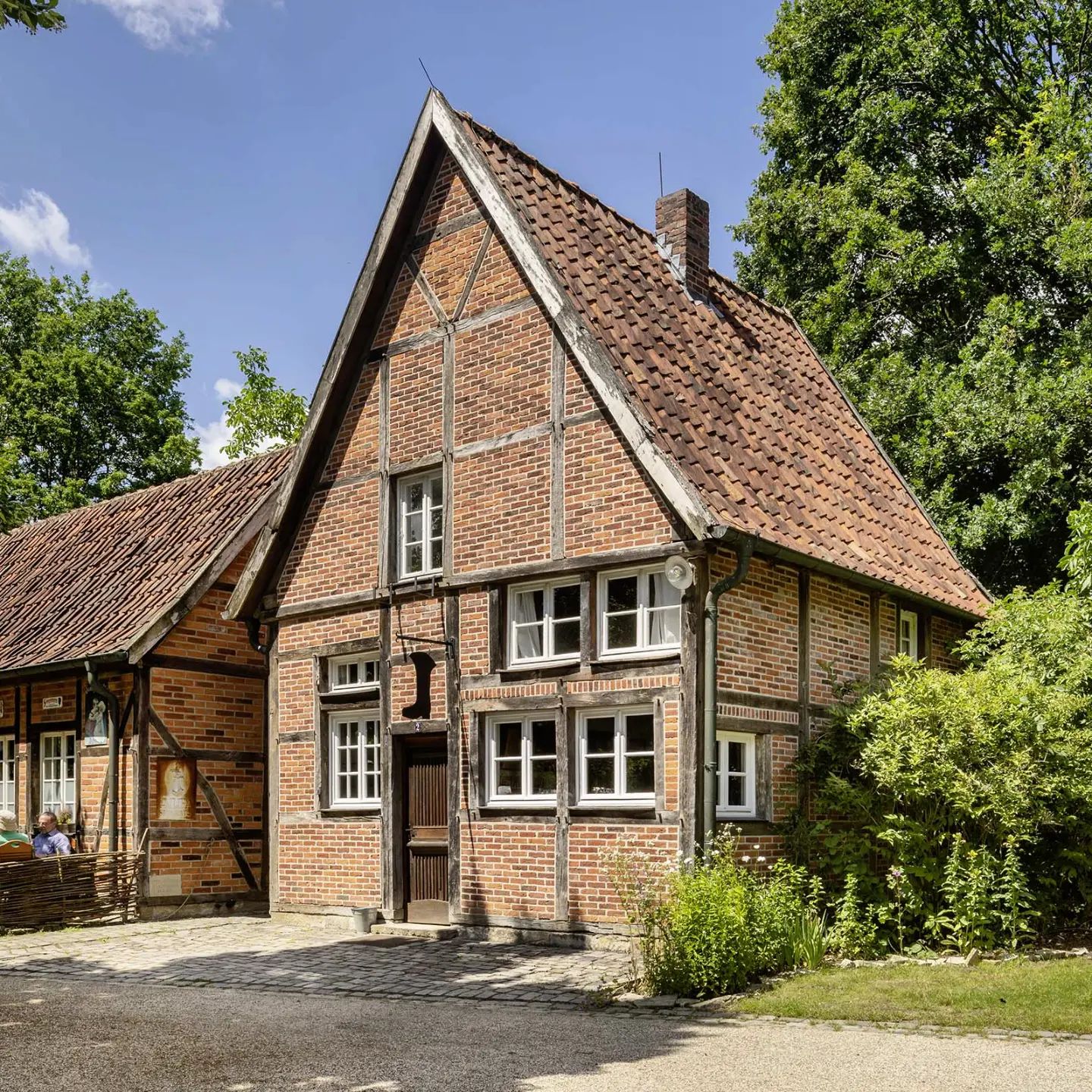 Das giebelständige Schuhmacherhaus wurde um 1820 in Herbern (Kr. Coesfeld) erbaut. Es kann als typisches Beispiel für kleine Handwerkerhäuser in den eng bebauten Dorfkernen des Münsterlandes gelten. In dem zweigeschossigen Fachwerkbau mit seinem auffallend steilen Dach betrieb bis in die 1960er Jahre der Schuhmacher Krampe sein Handwerk. 1981 überließ der letzte Eigentümer, H. Angelkort, das Haus dem Mühlenhof. Im Erdgeschoss ist heute eine Schuhmacherwerkstatt aus der Zeit um 1900 eingerichtet.