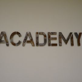 Das Logo unserer ACADEMY - in rostigem Stahl, wie es sich für ein cooles Industrieloft gehört.