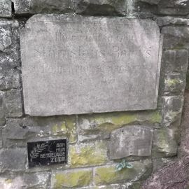 einzelne Grabsteine, Namensschilder, die in die Einfriedungsmauer integriert wurden
