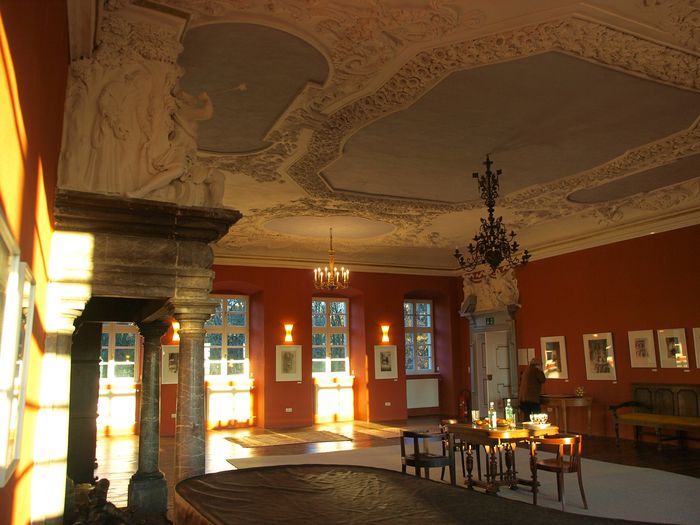 Der große Kaminsaal mit barocker Stuckdecke