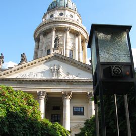 Der Französische Dom. Nordseite mit den Bäumen und einer Laterne davor.