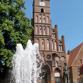 Rathaus der Stadt Brandenburg mit dem Brunnen davor.