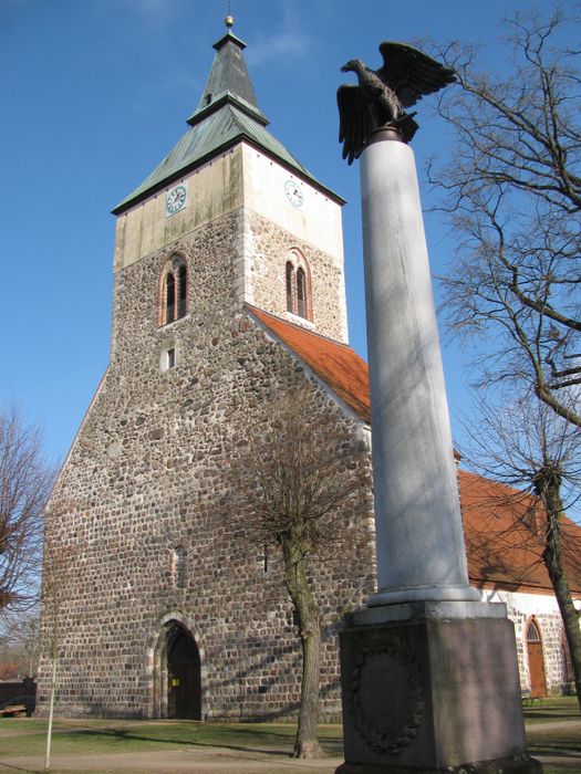 Stadtkirche Altlandsberg mit Denkmal davor. Feb. 2018.