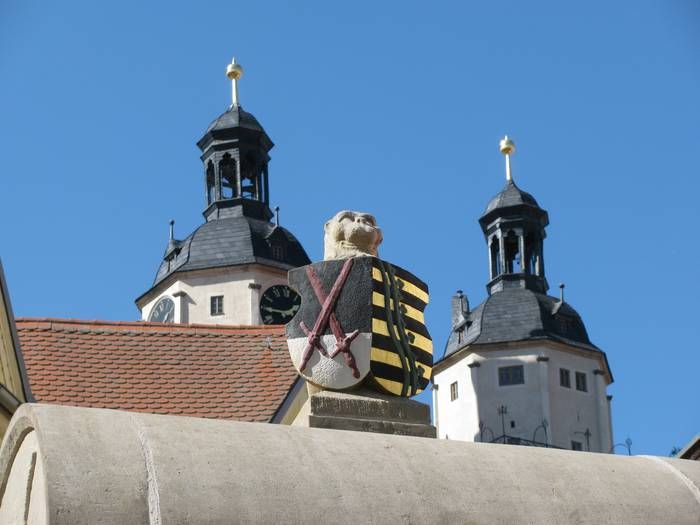 Das Brunnenwappen oben mit der Stadtkirche dahinter.