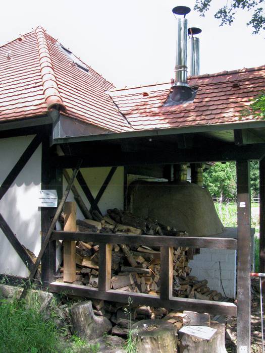 Der Open-Air-Brotbackofen mit Holzvorrat.