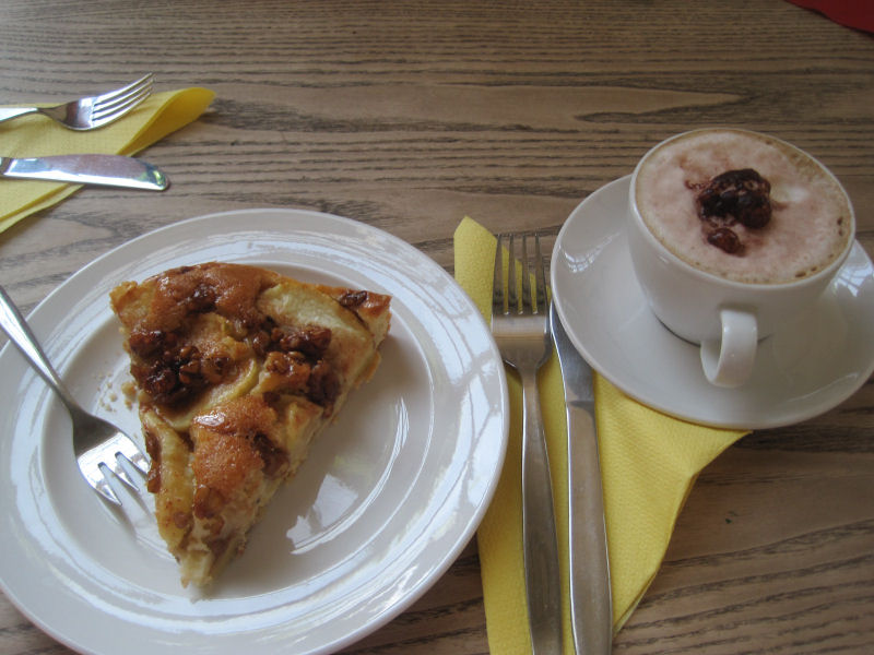 im Café. köstlicher Apfelkuchen mit gerösteten Walnüssen und Cappuccino