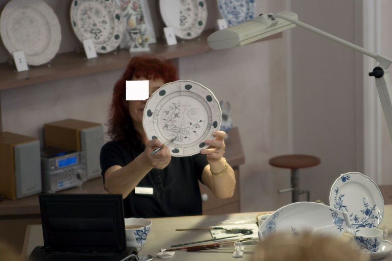 Die Dame erklärt, wie das Porzellan hergestellt und von Hand bemalt wird