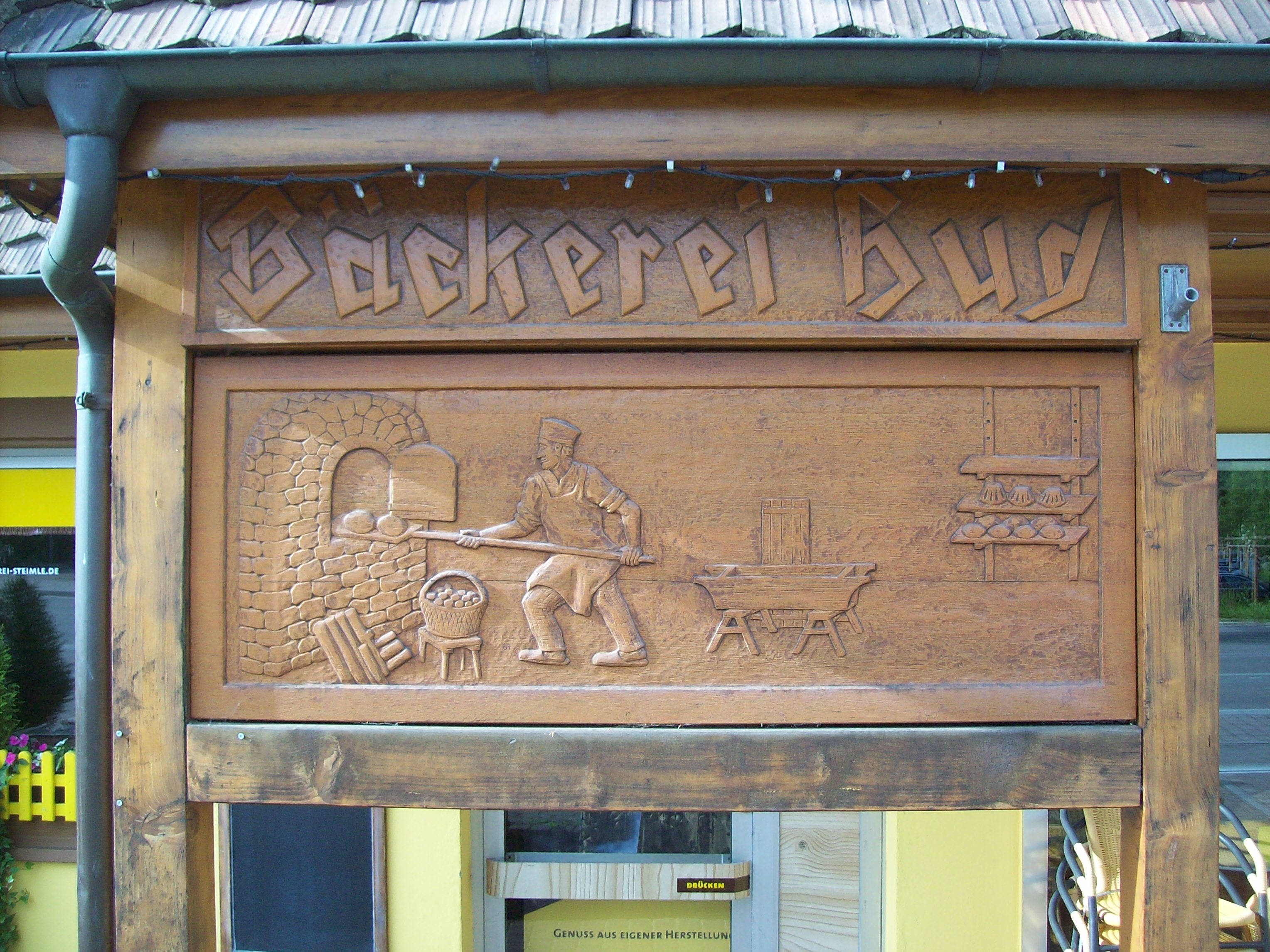 Holzschnitt der ehem. Bäckerei Hug vor dem Eingangsbereich