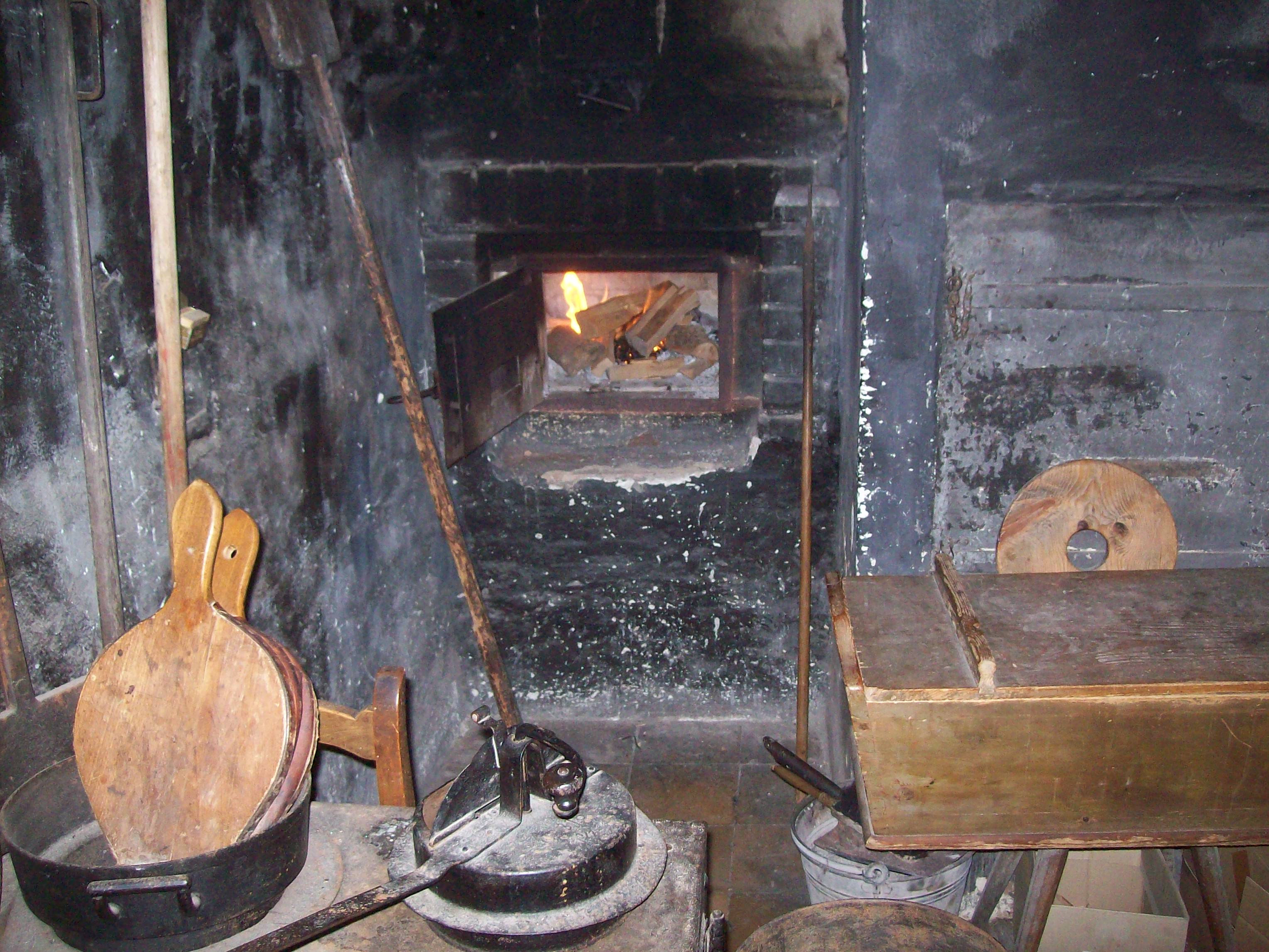 Blick in die Ofenöffnung in der verrauchten Küche zum Befeuren des Kachelofens in der guten Stube