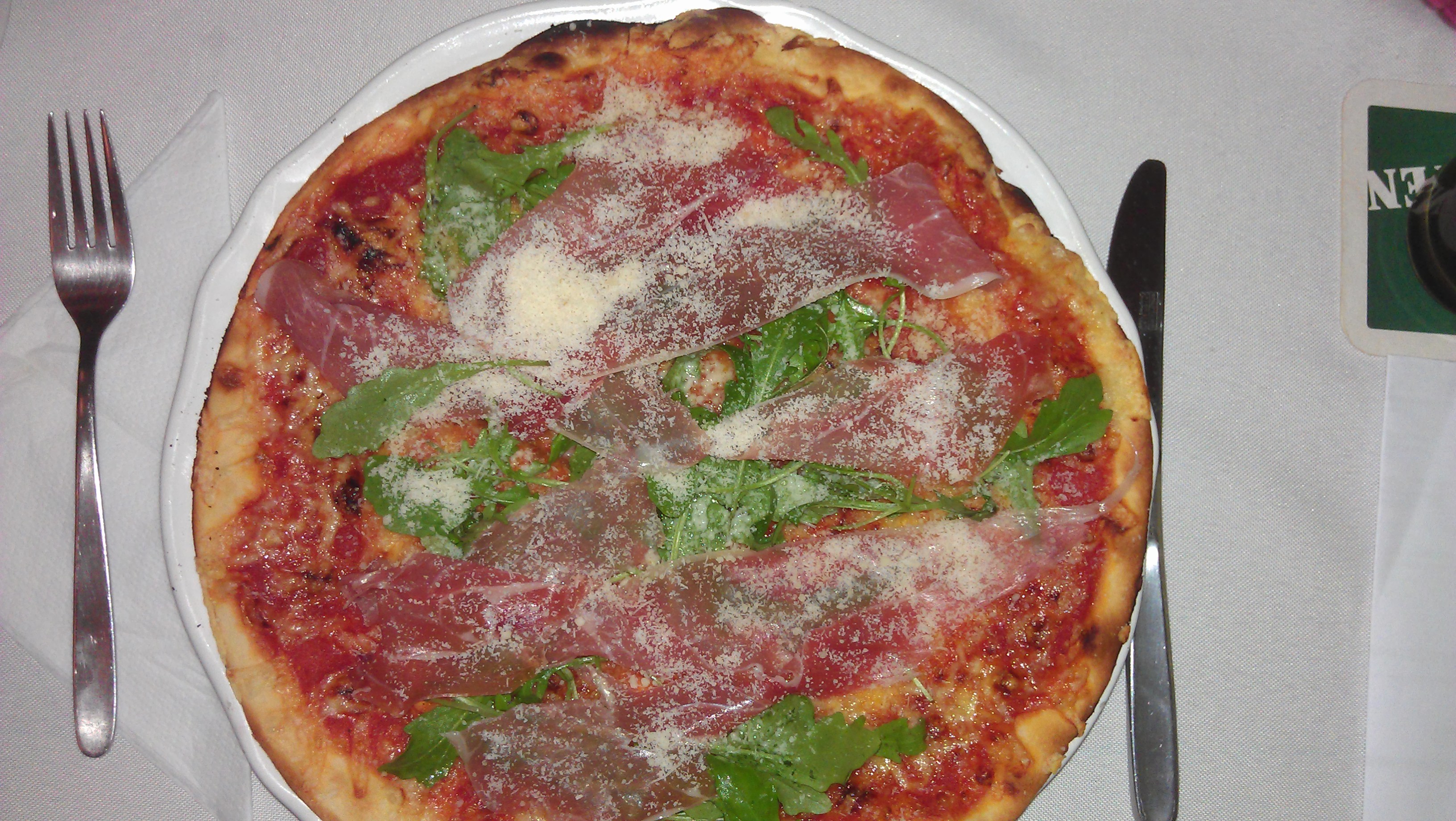 Pizza mit Parmaschinken, Rucola und Parmesan