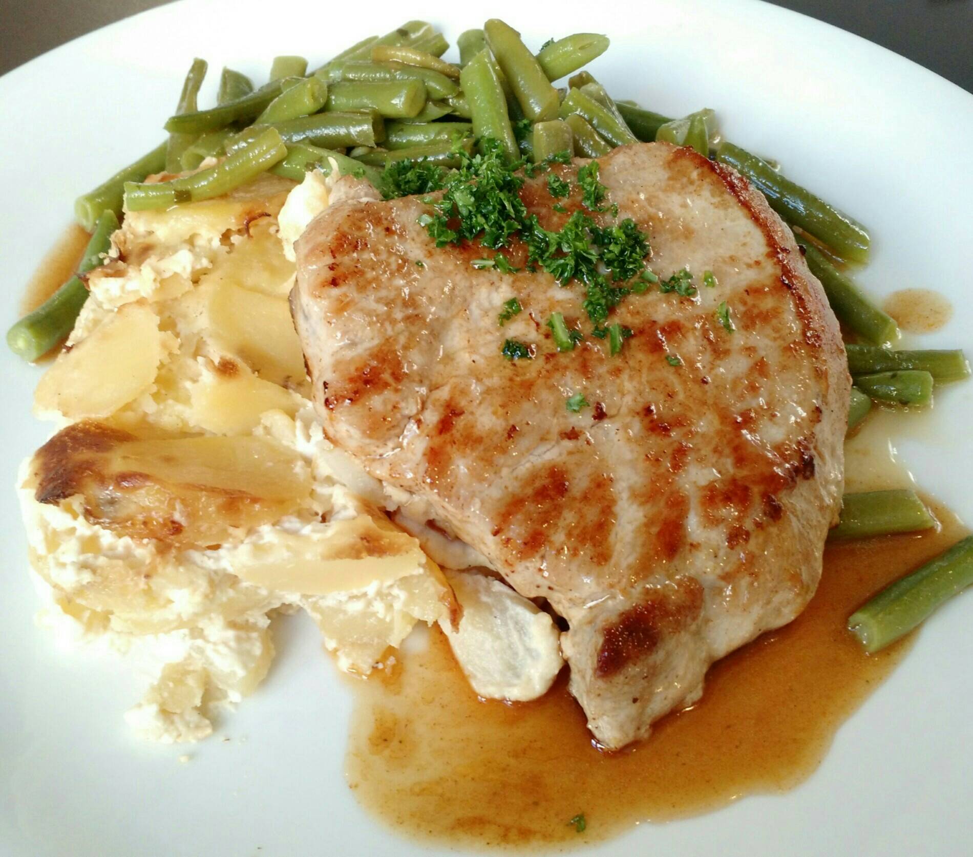 Gebratenes Schweinerückensteak mit Kartoffelgratin, Brechbohnen und Bratenjus