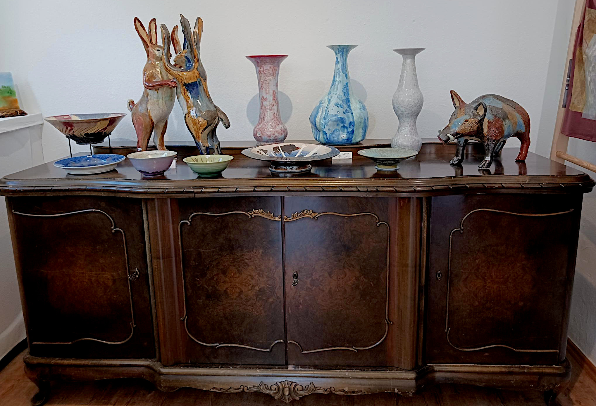 Hinterwand im Laden mit Exponaten - Vasen, Teller, Tierskulpturen