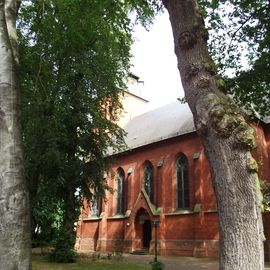 Evangelische Kirche, Gemeinde Alt-Aumund in Bremen Nord von hohen Bäumen umringt
