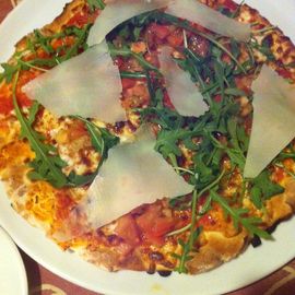 Pizza Ernesto, belegt mit Bruschetta, Mozzarella, Rauke und Parmesan