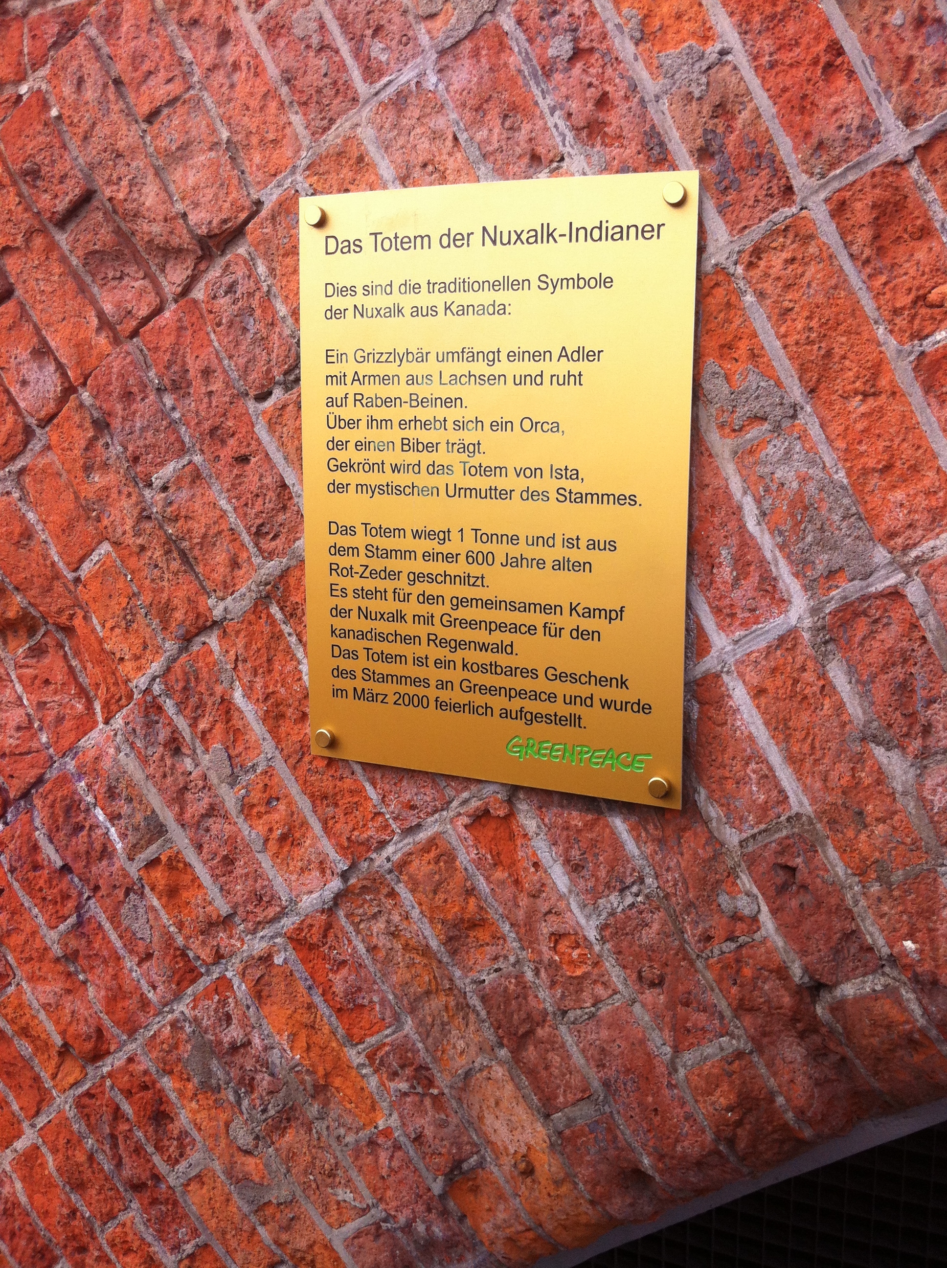 Info zum Totem der Nuxalk Indianer aus Kanada am Greenpeace Gebäude in Hamburg