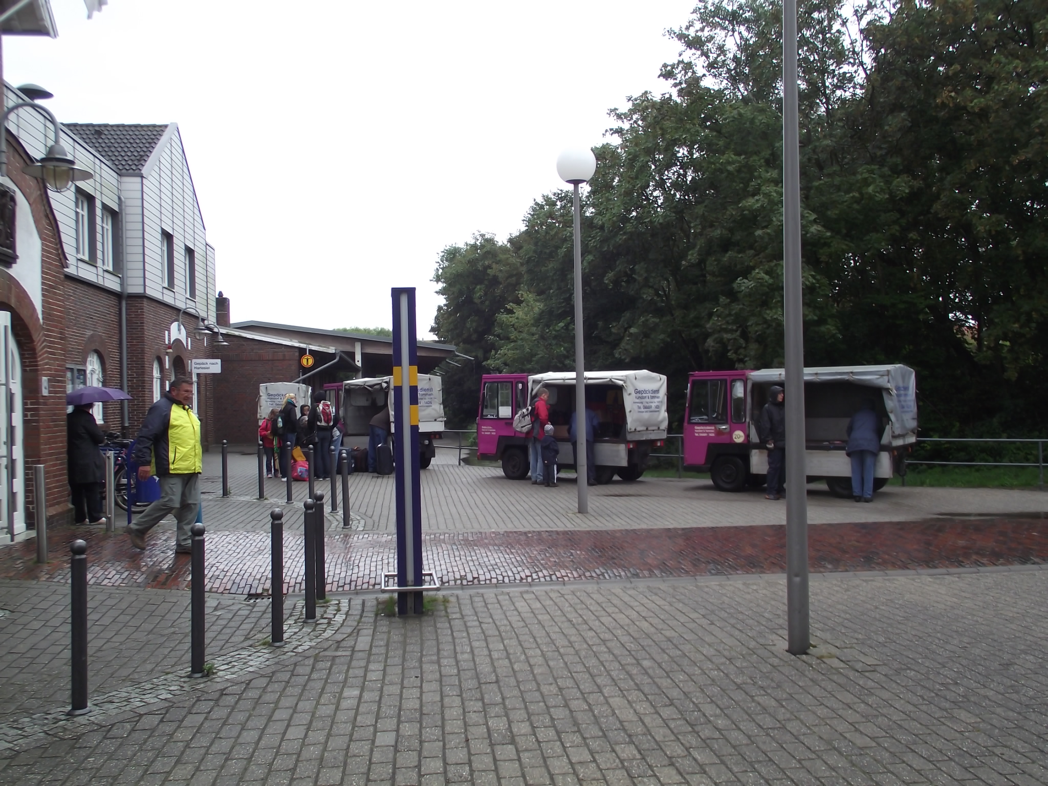 Ankunft am Bahnhof von Wangerooge mit der Inselbahn - Die elektrisch betriebenen Gepäckwagen warten auf Kundschaft