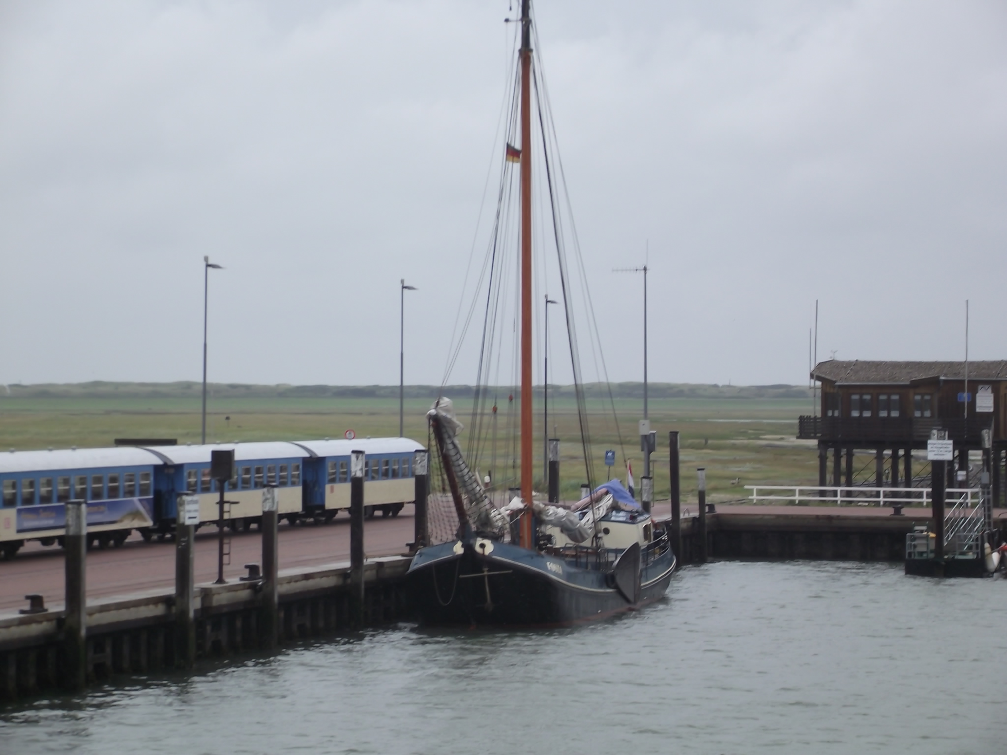 Anleger von Wangerooge - Die Inselbahn steht schon bereit, davor ein holländisches Schiff mit Seitenschwertern