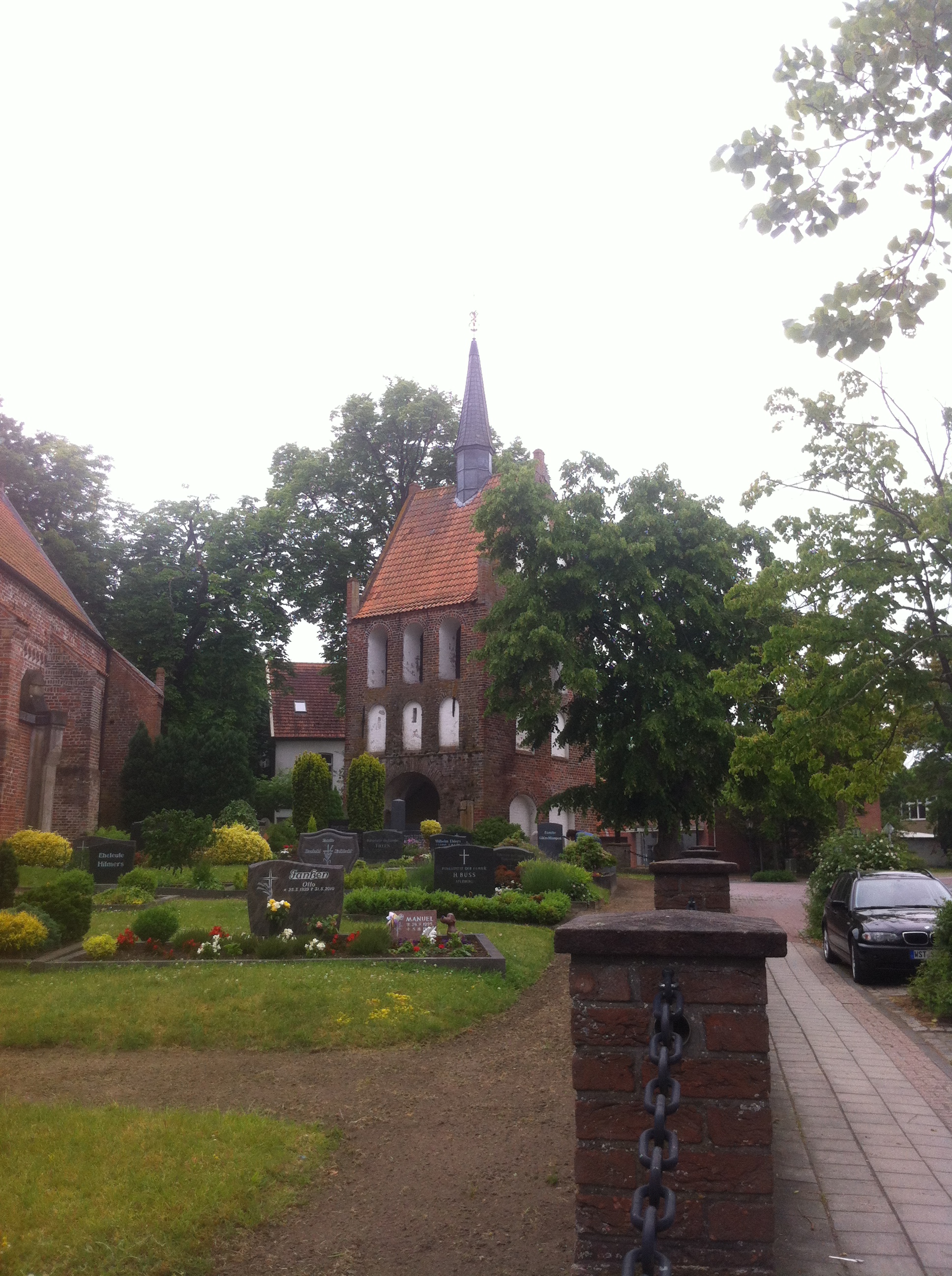 Blick über den Friedhof zum Glockenturm von Apen