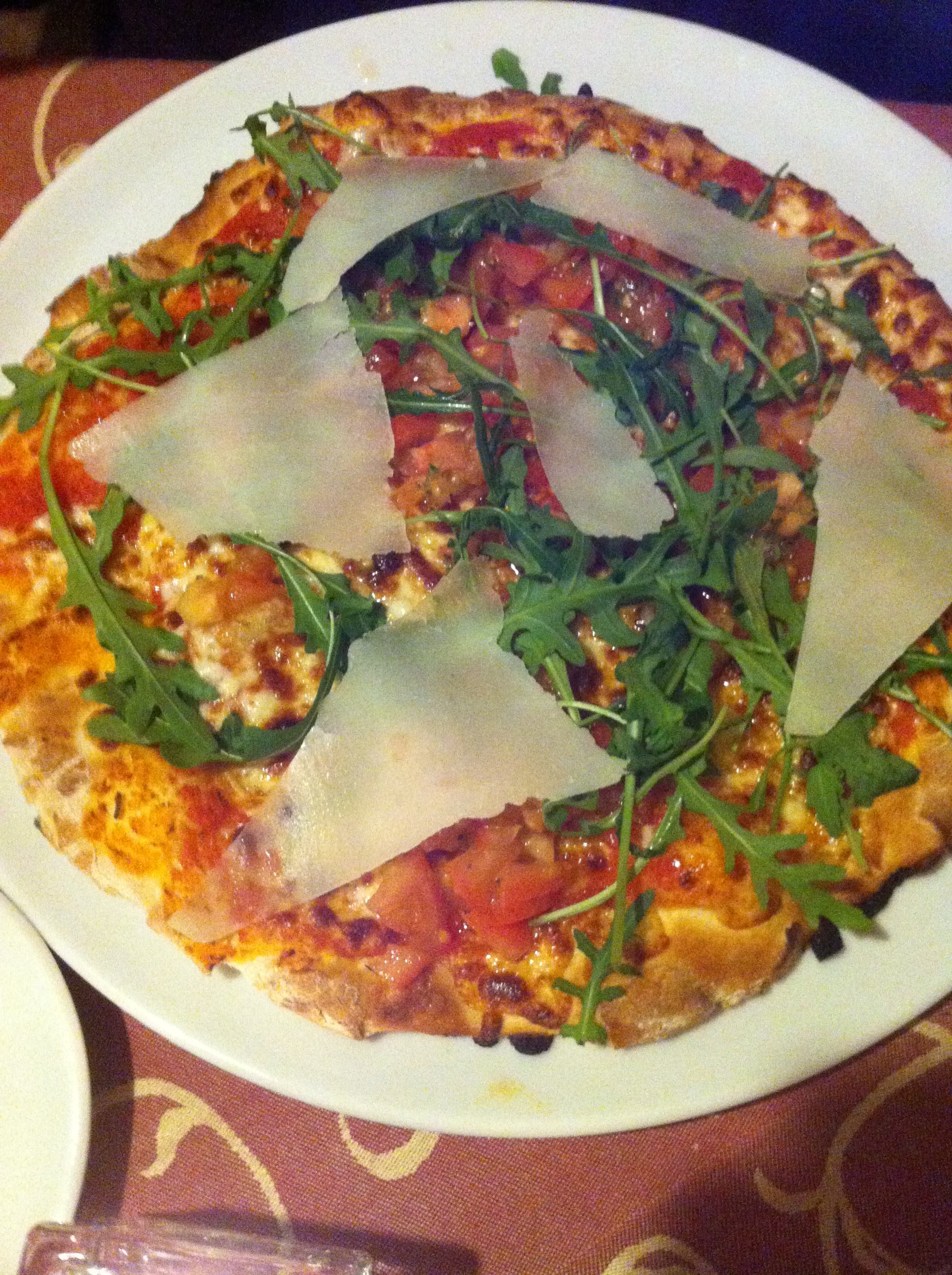 Pizza Ernesto, belegt mit Bruschetta, Mozzarella, Rauke und Parmesan