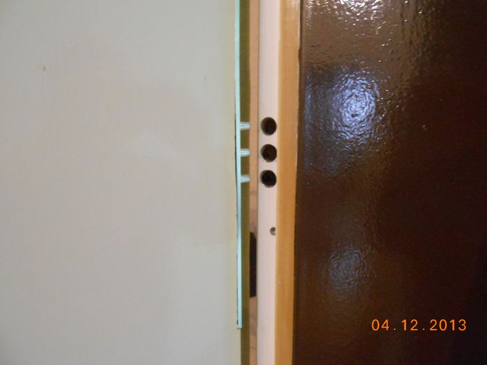 Bandsicherung mit drei Zapfen, je 1x oben und unten die in die Stahlzarge beim Schließen konisch greifen. 