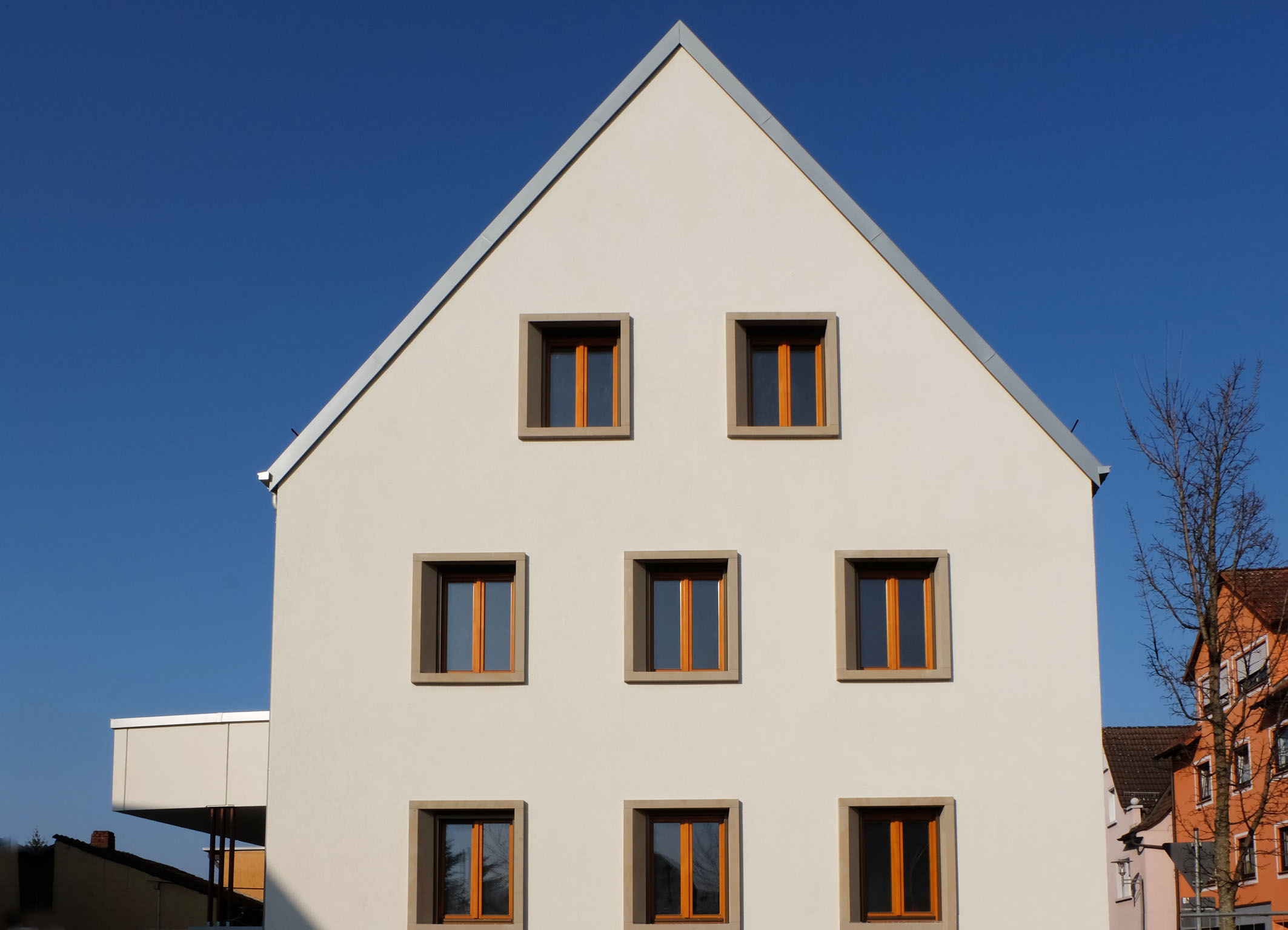 Neubau Mehrfamilienhaus Goldbach / klassisches Satteldach mit Lochfassade modern interpretiert