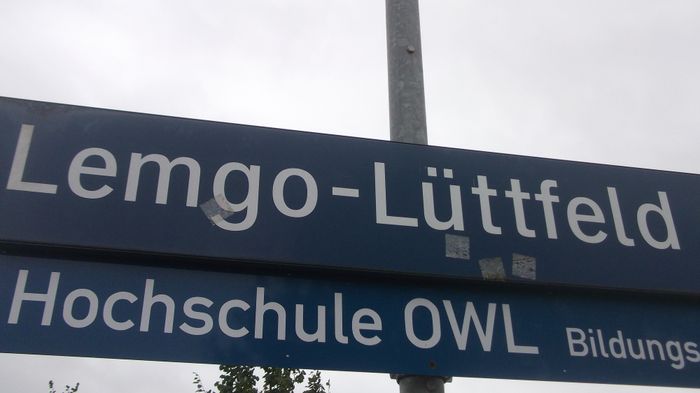 Bahnhofsschild Lemgo-Lüttfeld- mit dem Verweis auf die hiesige Hochschule