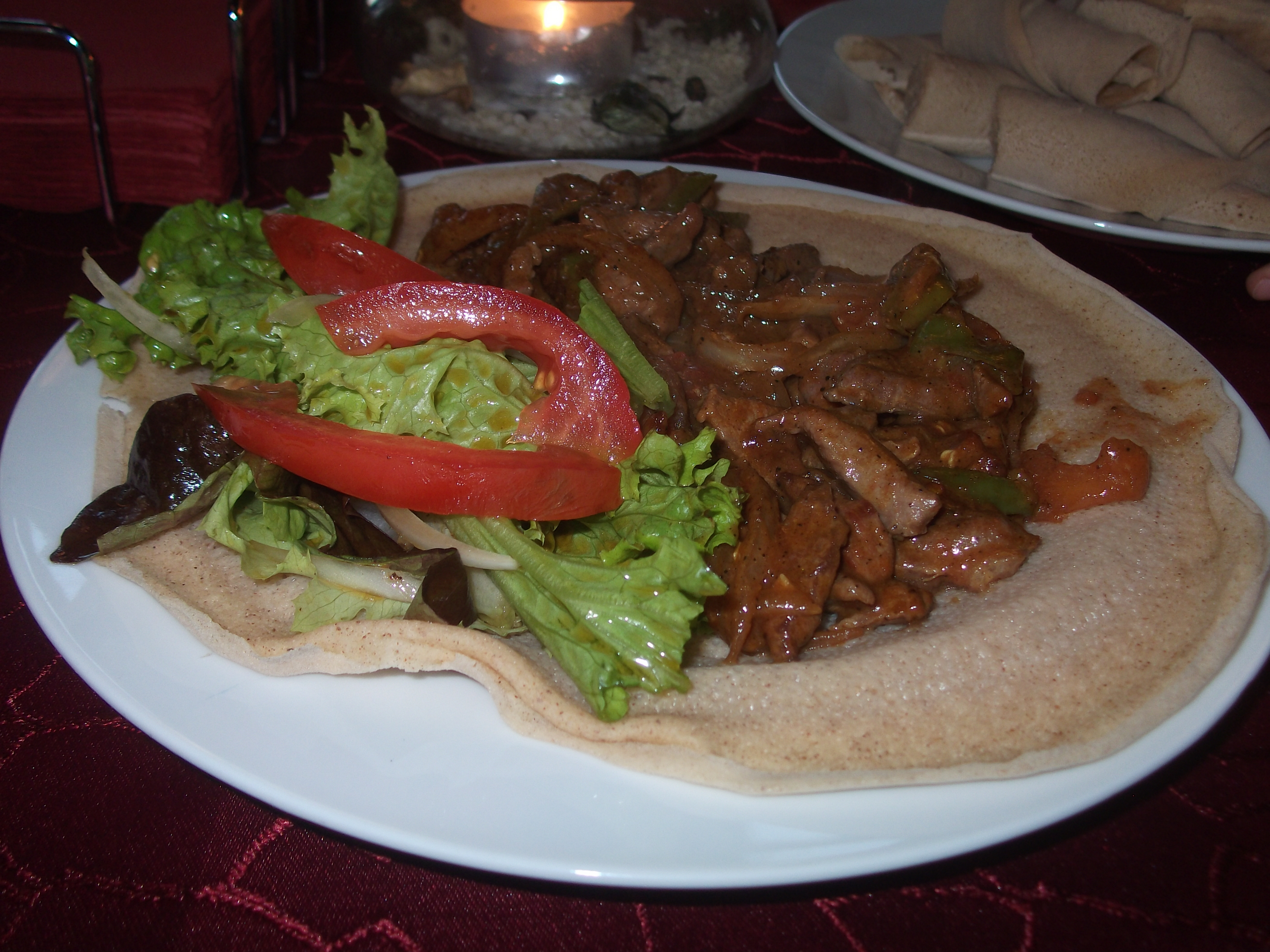 Fladenbrot mit äthiopischen Genüssen: gebratenes Ziegenfleisch manieriert und mit Gemüse serviert