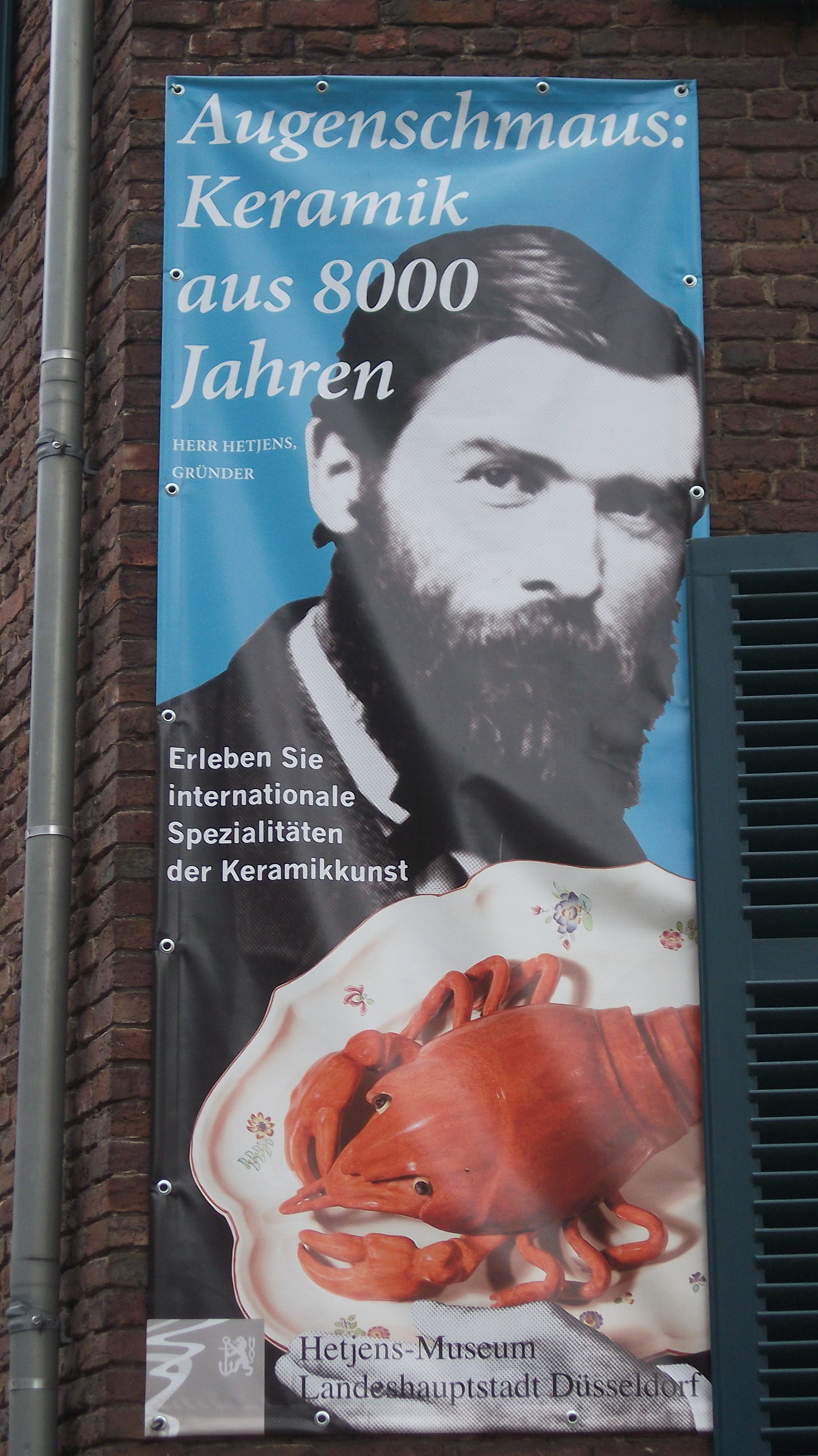 Plakat mit dem Portrait des Stifters: Laurenz Heinrich Hetjens auf der Wand am Palais Nesselrode