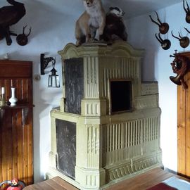 Kachelofen mit zwei tierischen Bewohnern im Historischen Gasthof zum Adler in Großholzleute