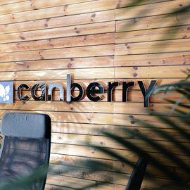 Das Logo der Canberry GmbH auf einer Holzwand im B&uuml;ro