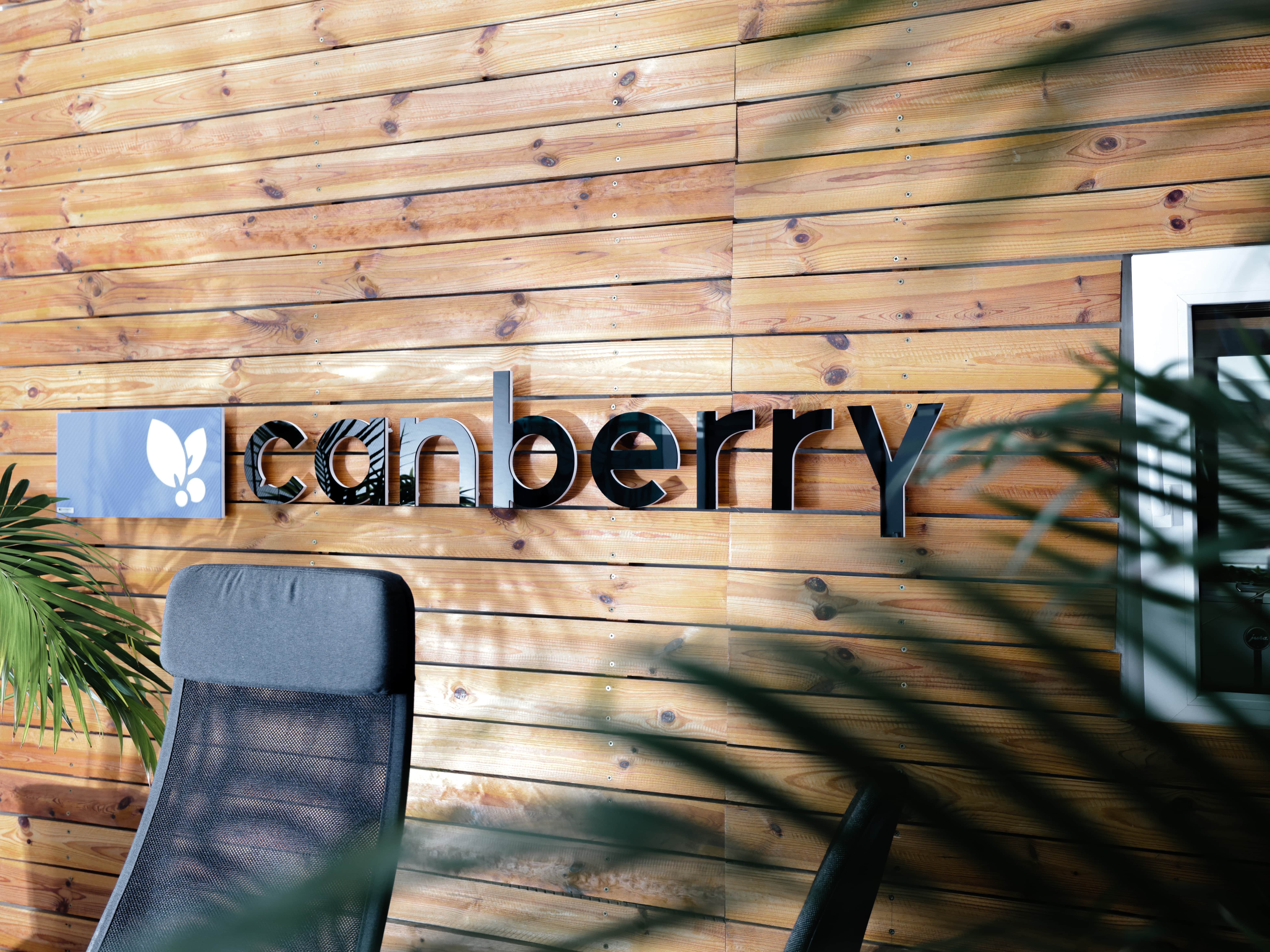 Das Logo der Canberry GmbH auf einer Holzwand im B&uuml;ro