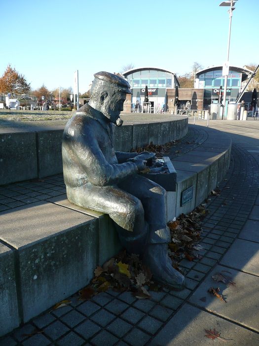 Skulptur Sitzender Fischer und Heringstafeln