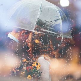 Brautpaar mit Schirm im Regen