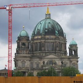 Der Berliner Dom, malerisch eingerahmt von Kränen auf der Schlossbaustelle.