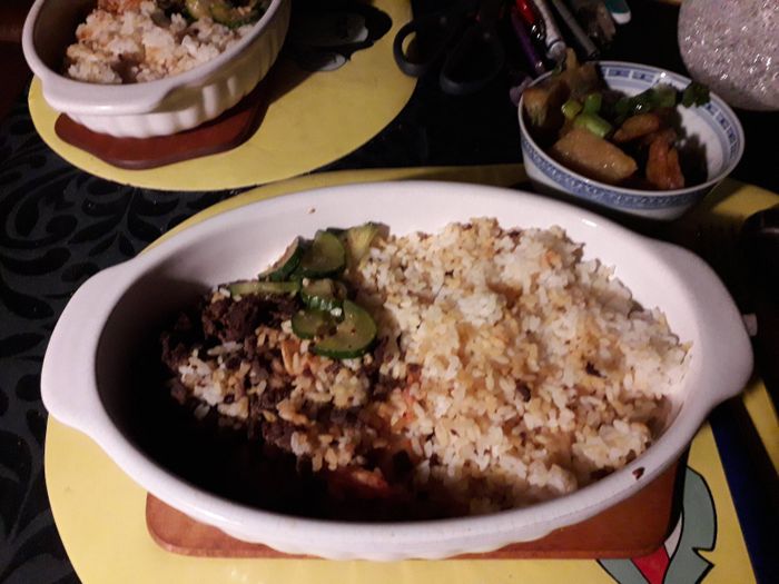 Mariniertes Rindfleisch mit Reis, im Hintergrund Gemüsepuffer.