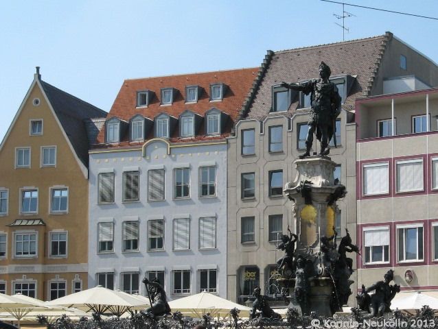 Café Eber am Rathausplatz. Die Schirme gehören dazu; links neben dem Brunnen die oberen Fenster des Cafés.