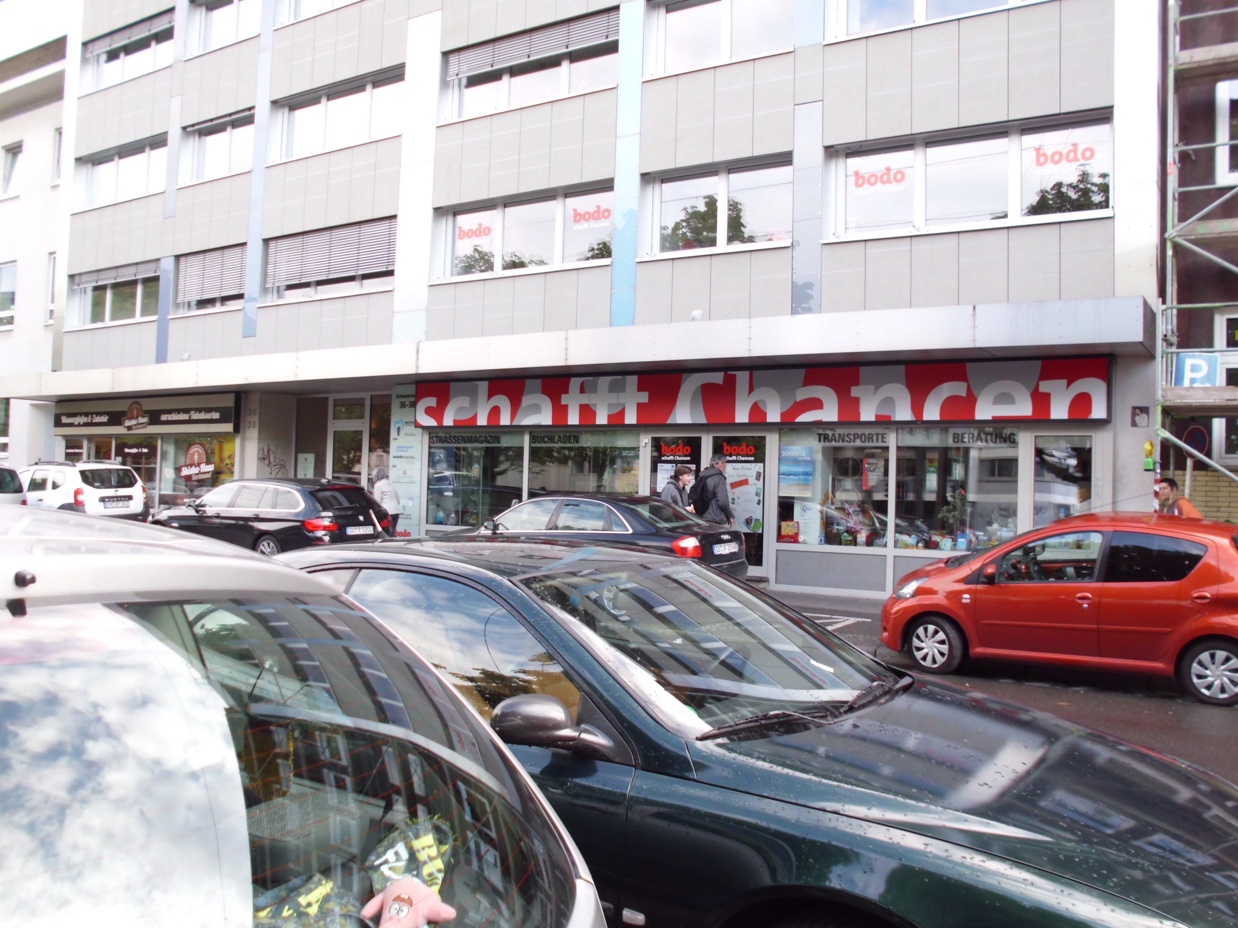 Blick vom vollbesetzten Parkplatz auf die Bodo Buchhandlung in Dortmund