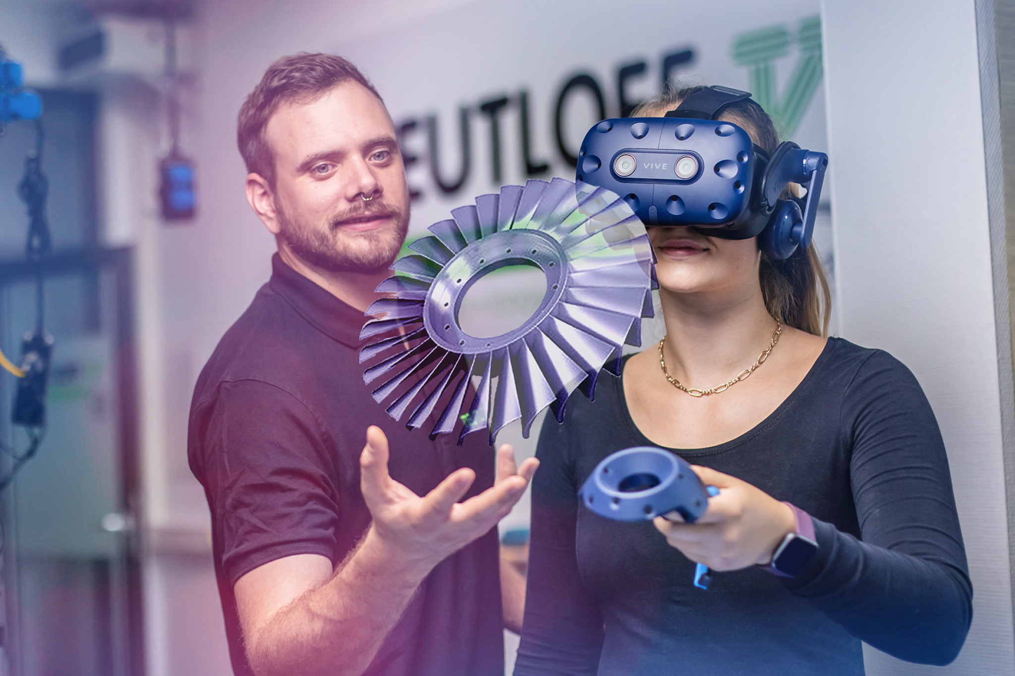 Dozent zeigt Schülerin die Bedienung eines VR-Headsets