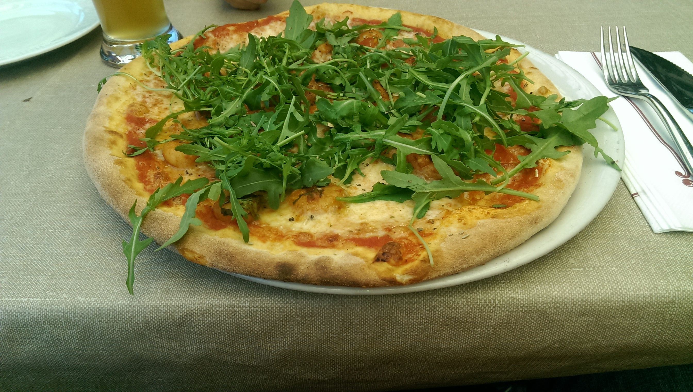 Pizza mit Scampi, Rucola, Tomaten und Käse