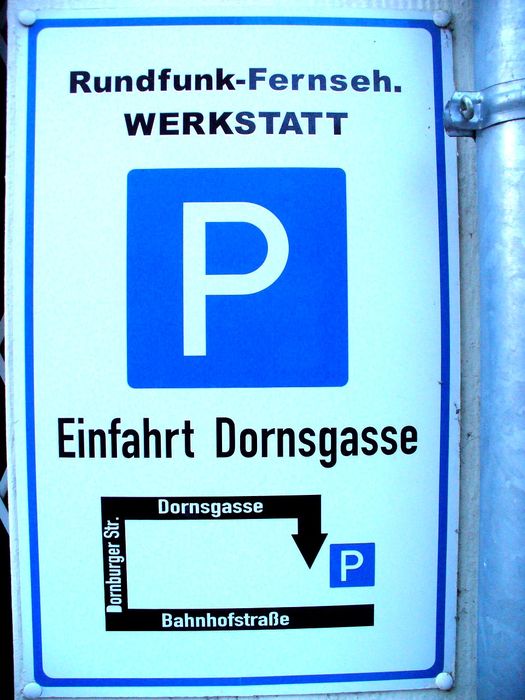 Wegweiser für den Privatparkplatz (zum Ein-/Ausladen) an der Rückfront des Geschäftes in der Dornsgasse.