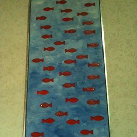 Auf dieser Holztafel sind Fischformen ausgespart. Wenn ein Kind getauft wird, kommt ein Fisch mit seinem Namen in die Tafel.